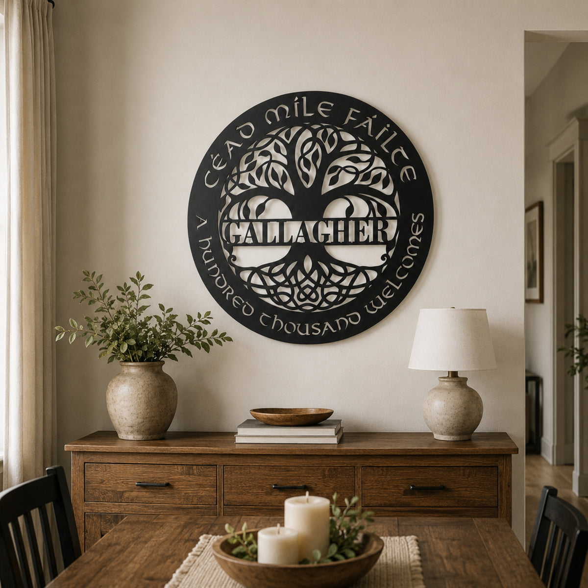 A round black metal wall sign with a Celtic tree design and the Gaelic phrase 'Sead mile faile Callachan A haidhle thrao mhoile wathoch' displayed in a warm, styled dining room above a wooden sideboard. Main image