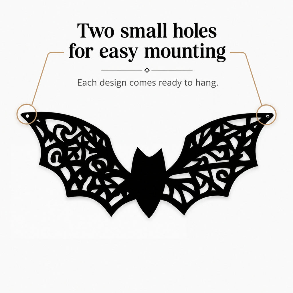 Black bat-shaped wall hanging with intricate cutout wing patterns, shown on a light gray background with text reading 'Two small holes for easy mounting' and 'Each design comes ready to hang.'.