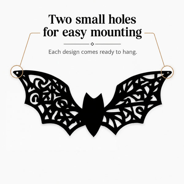 Black bat-shaped wall hanging with intricate cutout wing patterns, shown on a light gray background with text reading 'Two small holes for easy mounting' and 'Each design comes ready to hang.'.