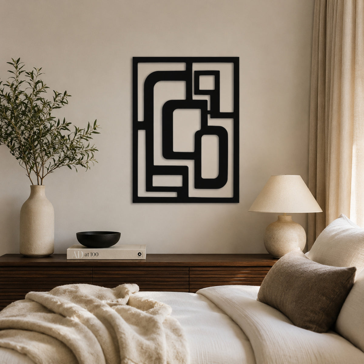 A black geometric wall art print with an abstract maze-like pattern, displayed in a modern bedroom setting above a wooden nightstand.