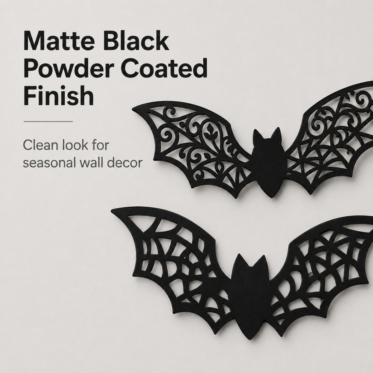 Two black bat-shaped wall decorations with intricate cutout wing patterns, shown on a light gray background with text describing a matte black powder-coated finish.