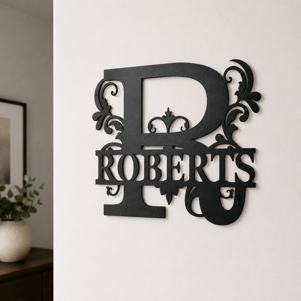 A black metal wall decor piece featuring a large ornate letter R and the name ROBERTS, mounted on a white wall in an indoor setting.
