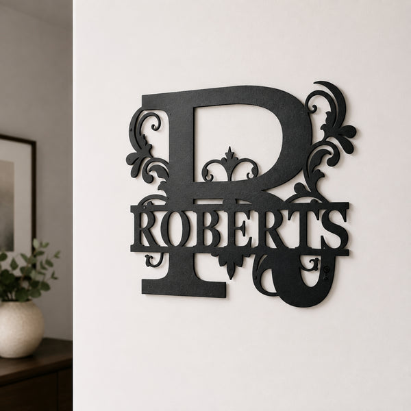 A black metal wall decor piece featuring a large ornate letter R and the name ROBERTS, mounted on a white wall in an indoor setting.