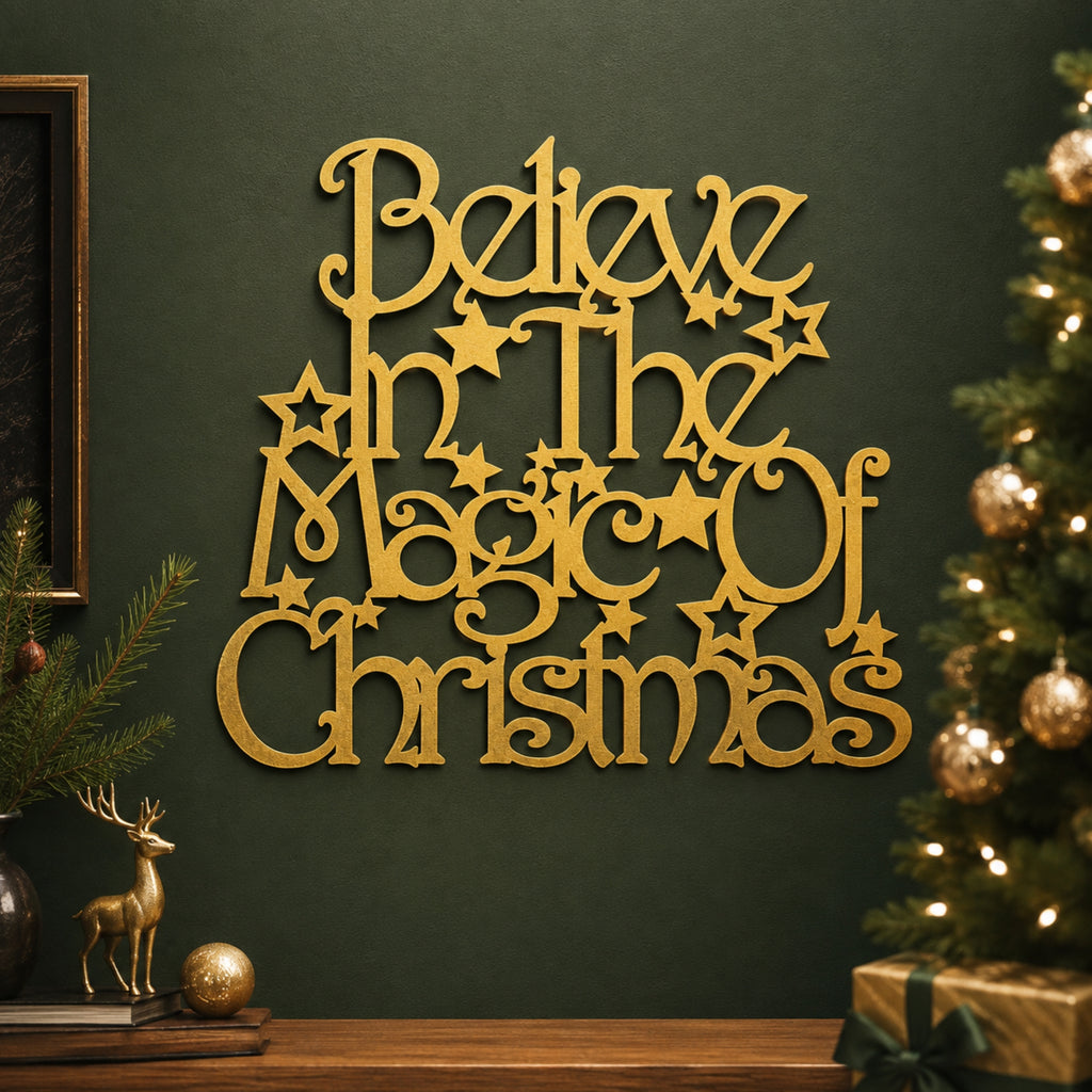 Gold wooden wall art reading 'Believe in the Magic of Christmas' with star details, mounted on a dark green wall above a holiday mantel with a Christmas tree, gold ornaments, and a small deer figurine.
