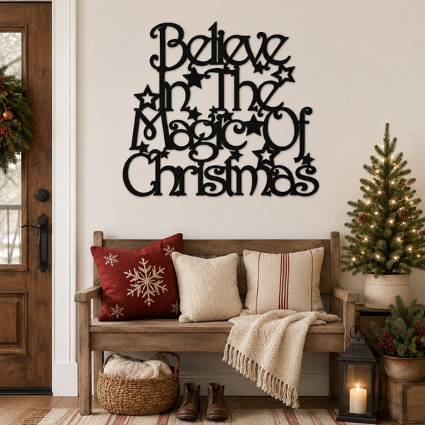 Black metal wall art reading 'Believe in the Magic of Christmas' displayed above a wooden bench in a decorated holiday living room setting.